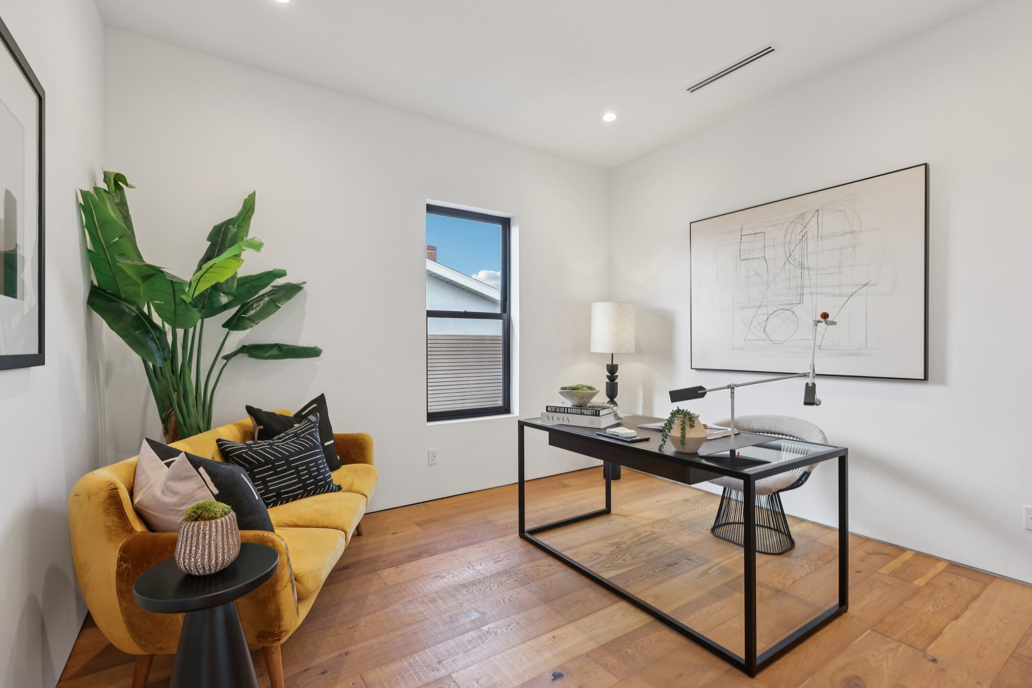 Home office with glass desk and lounge seating